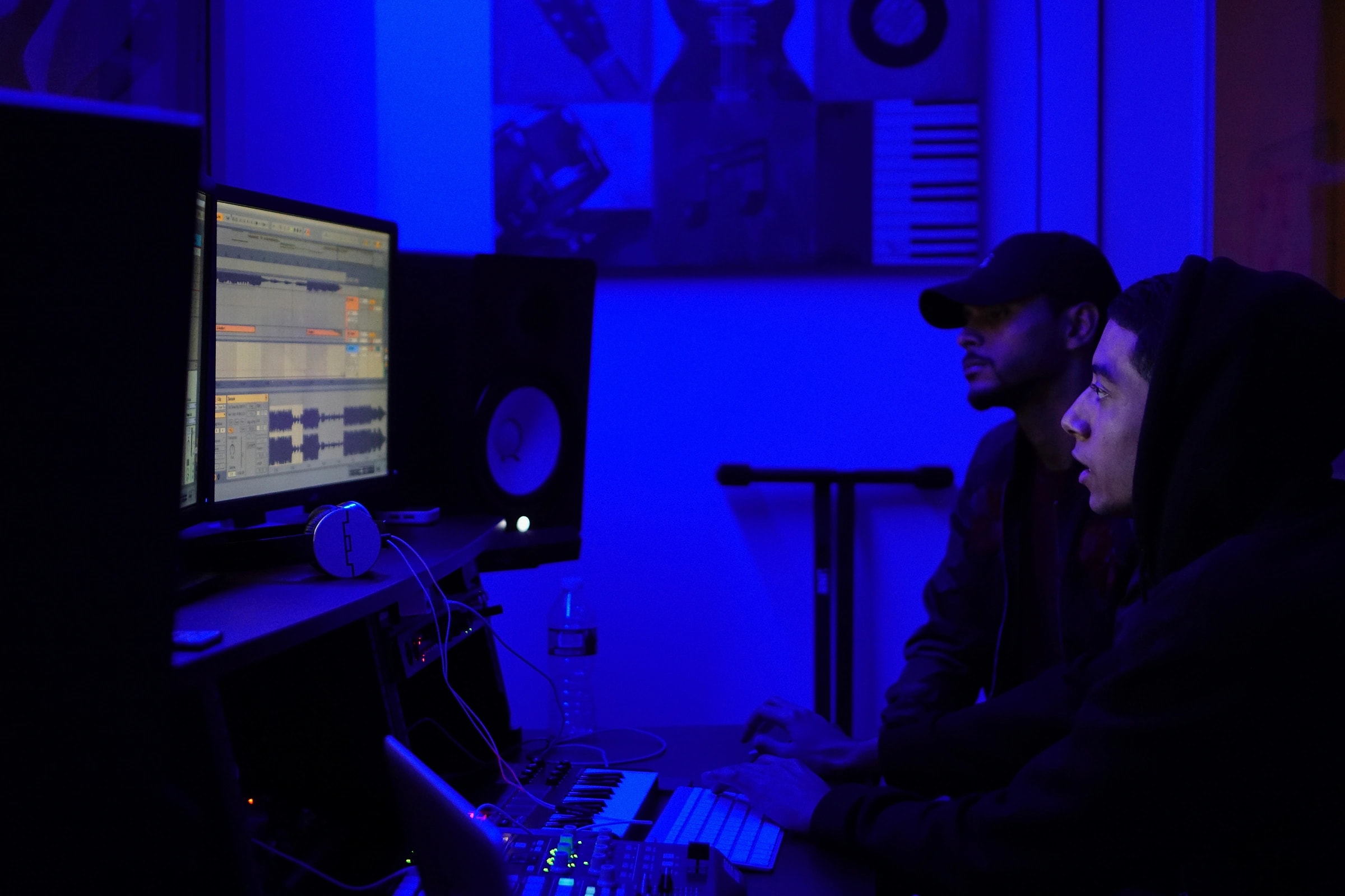 Two creators mixing a session at the DAW under blue studio light at Gifted Studios