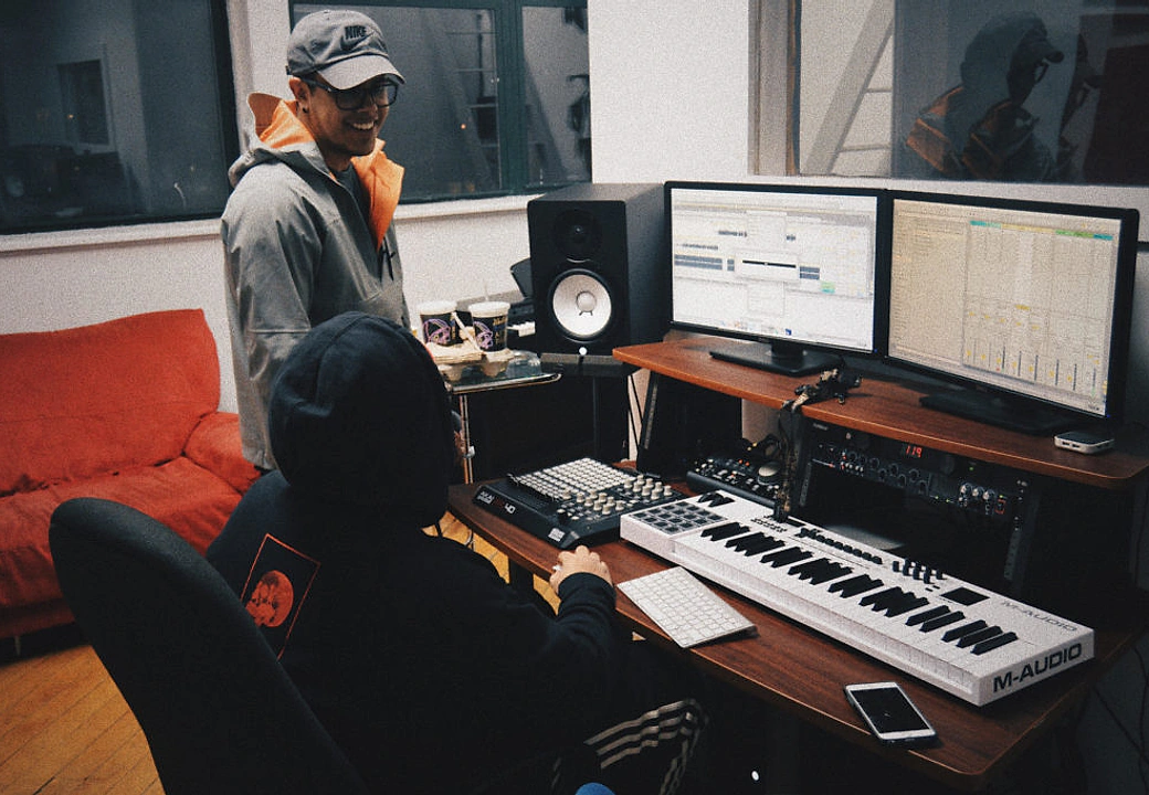 Two creators at the Gifted Studios desk with MIDI controllers and studio monitors