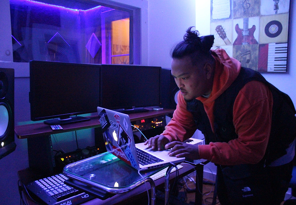 A creator focused on a laptop session in the purple-lit Gifted Studios room