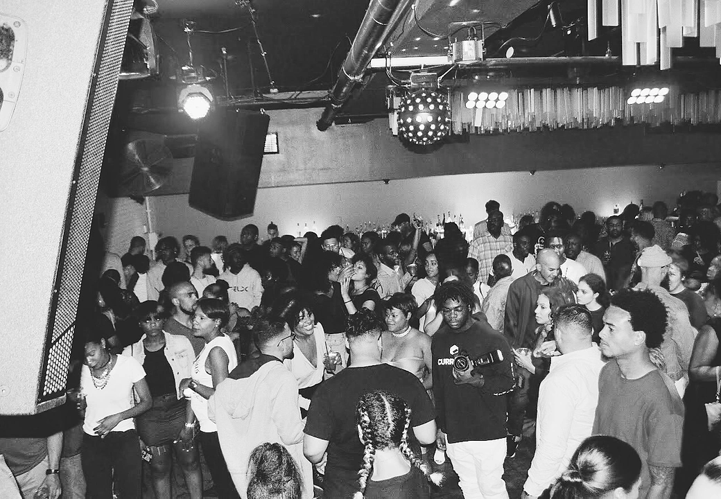 A crowd on the floor, shot in black and white, at a HEAT event