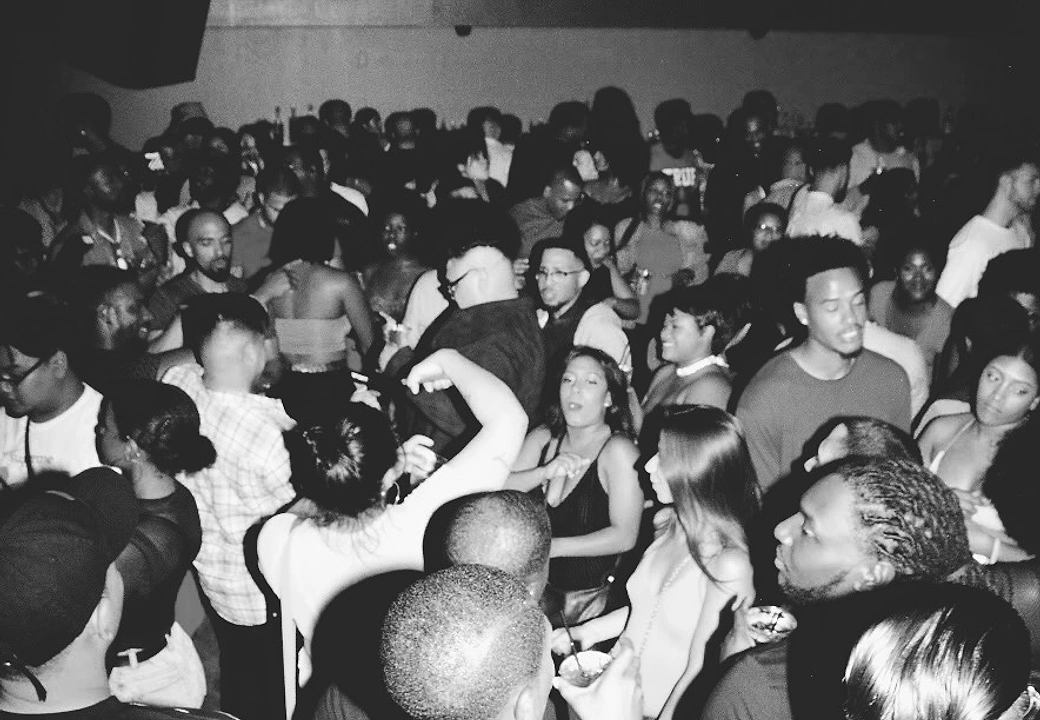 A packed crowd, shot in black and white, at a HEAT event