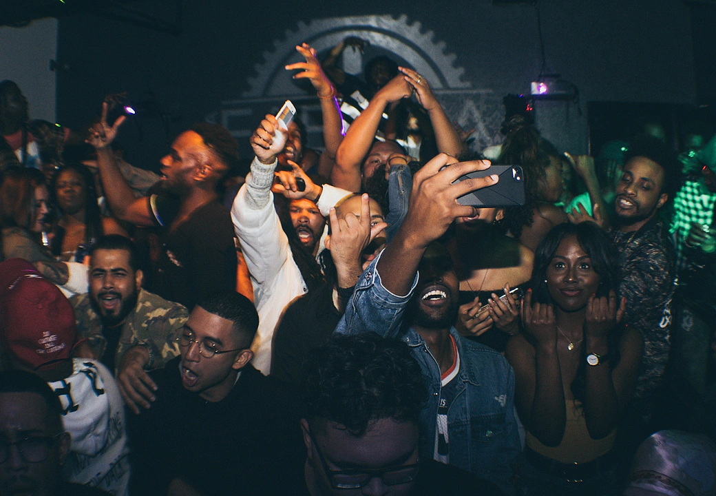 The crowd with their hands up under stage light at a HEAT event