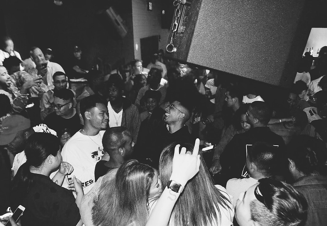 A packed crowd shot in black and white at a HEAT event