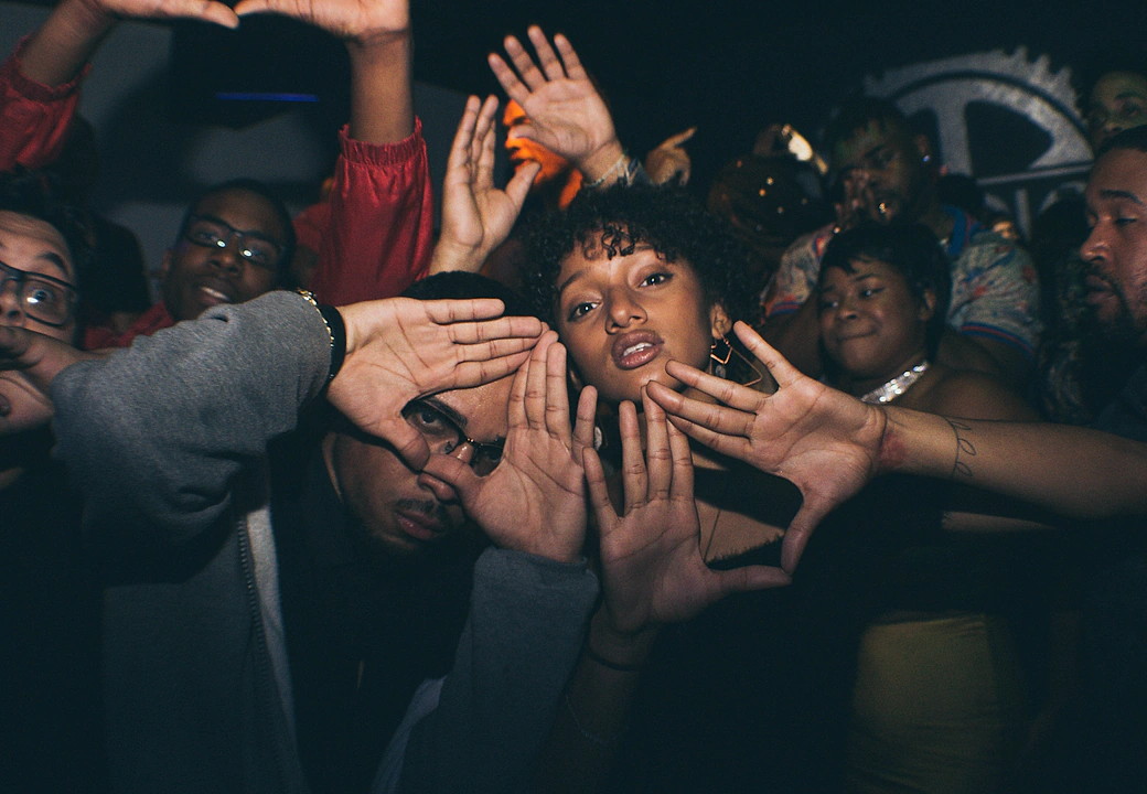 Attendees throwing up hand signs to the camera at a HEAT event