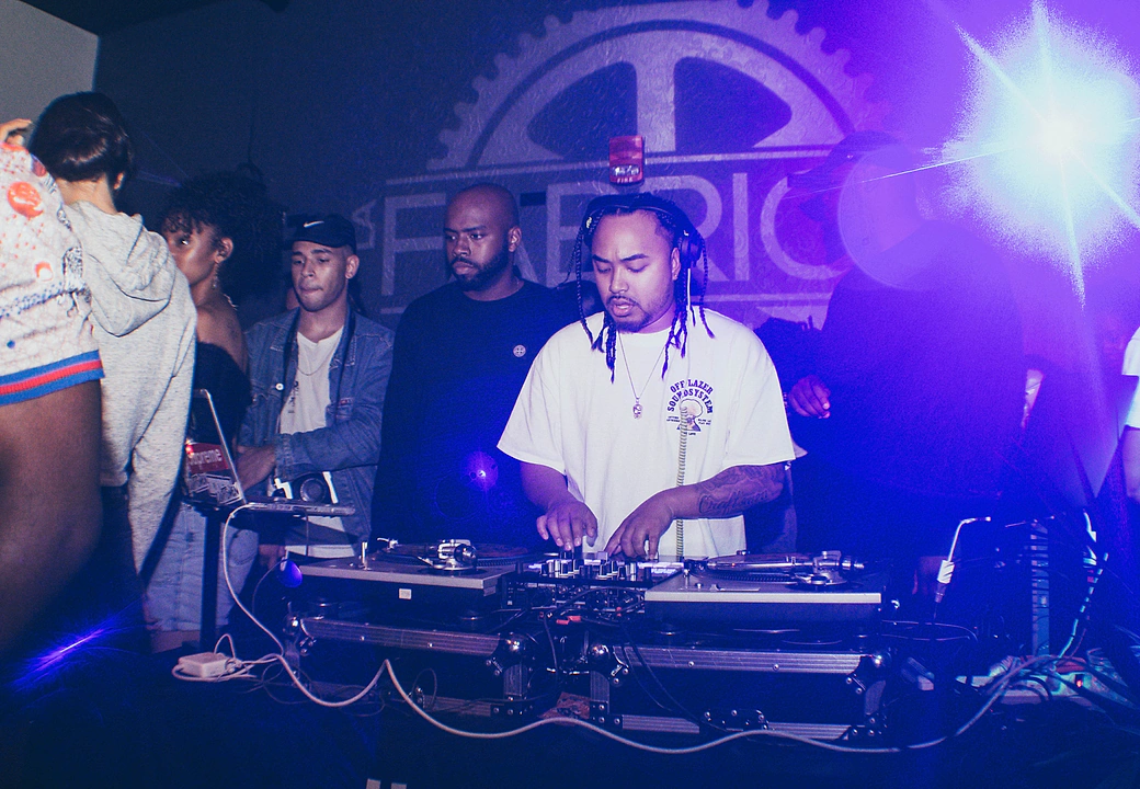 A DJ on the decks under the venue banner at a HEAT event
