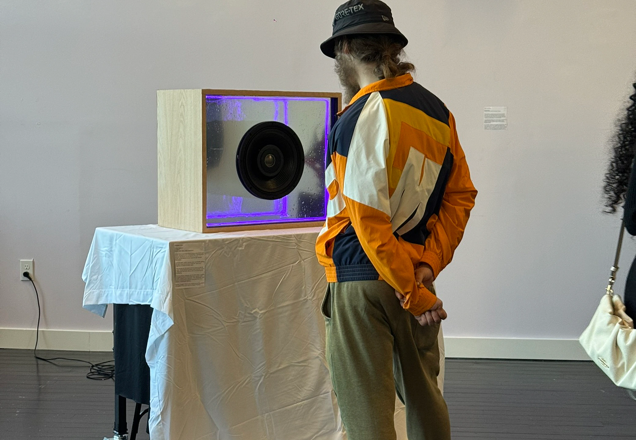 Visitor leaning in to the glowing purple infinity-mirror core