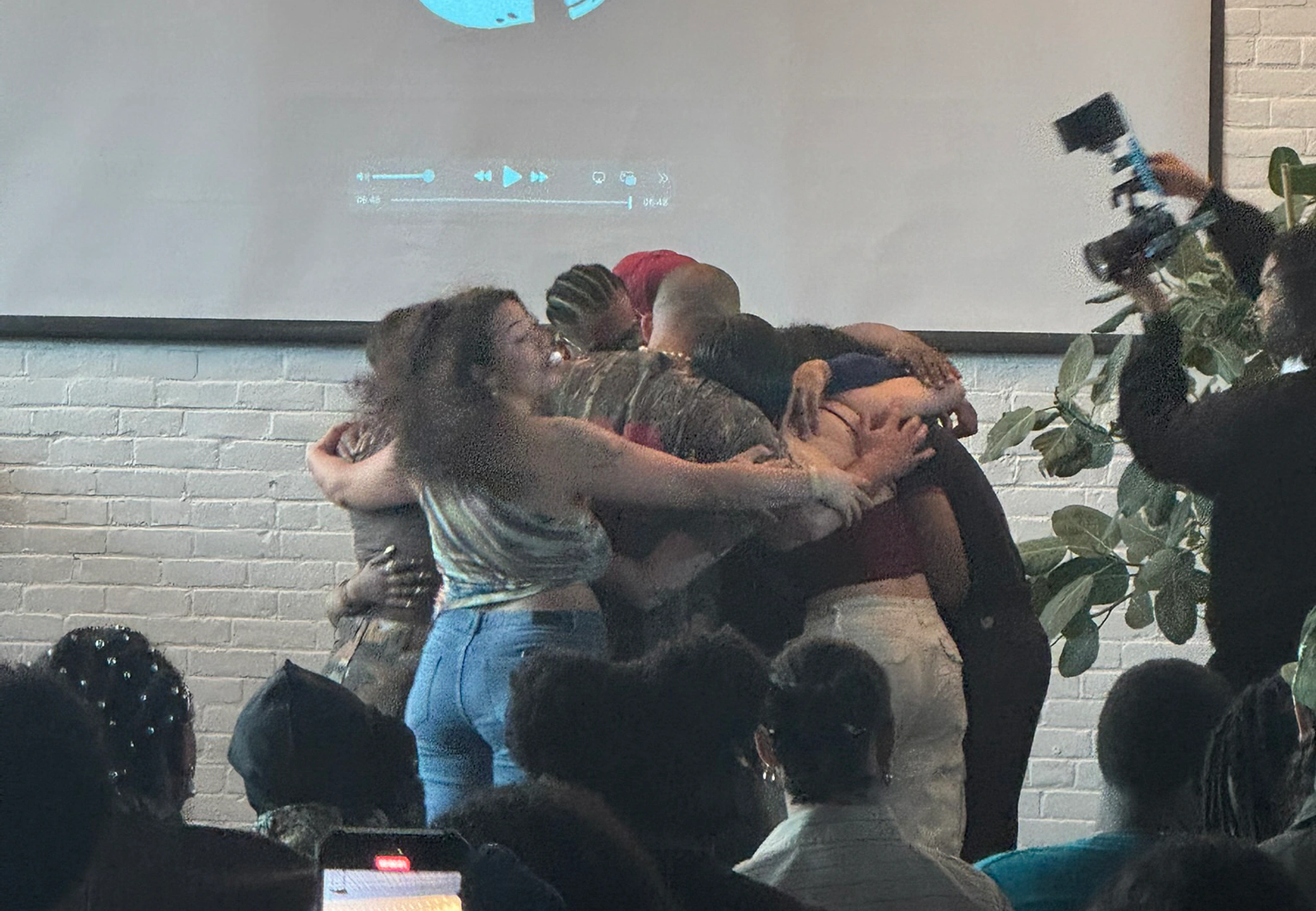 Celebration huddle on stage at the Artist Evolution Camp showcase